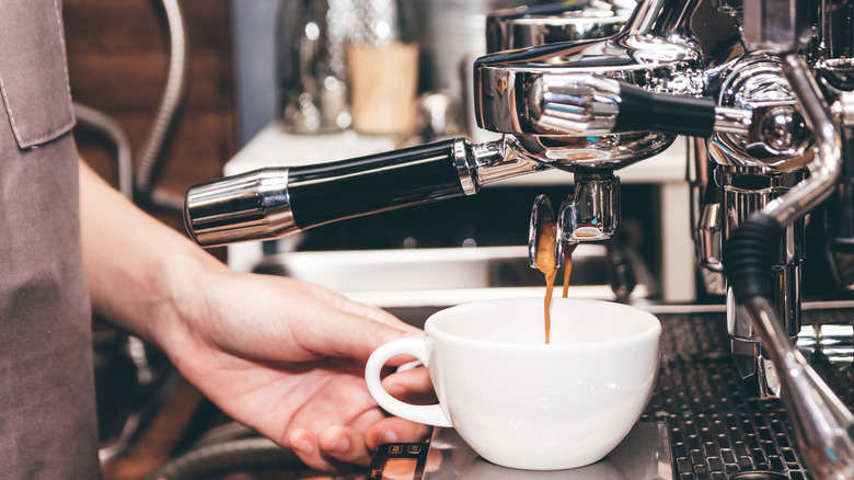 White cup being filled with coffee