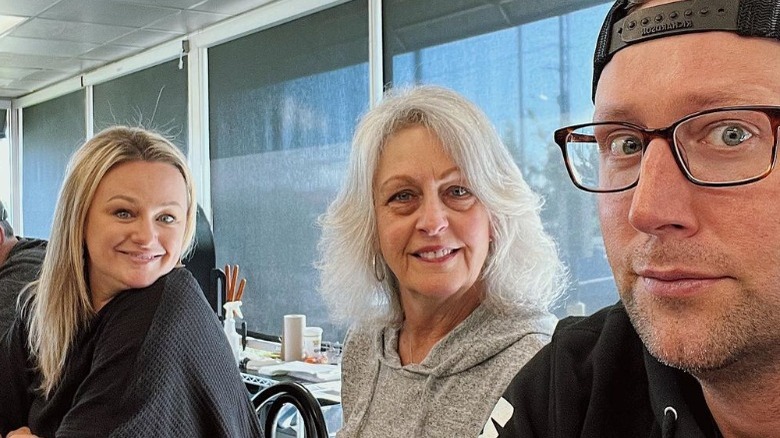 Alex Belew posing with his wife and mother