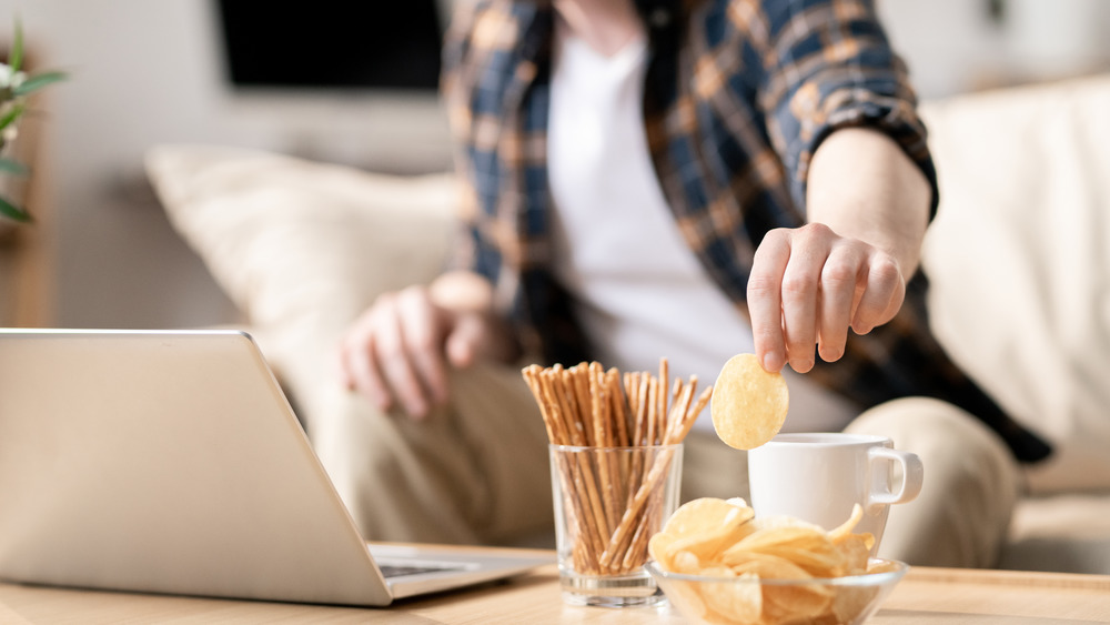 Man eating snacks while working