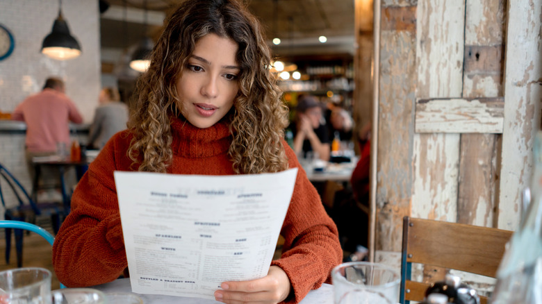 woman reading menu in restaurant