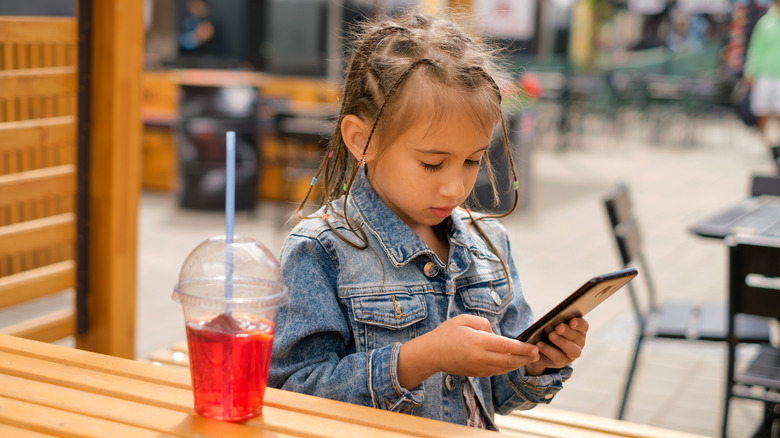 child sitting at a table on a patio