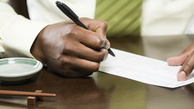 person signing restaurant bill