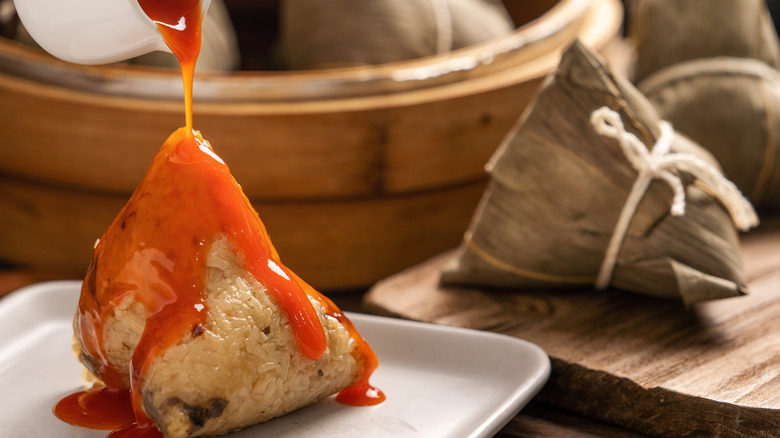 Zòngzi dumplings on white plate with red sauce