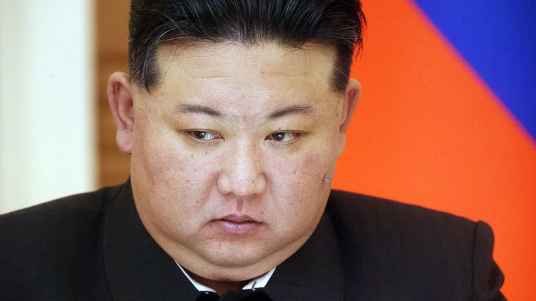 Kim Jong-Un close up in front of North Korean flag
