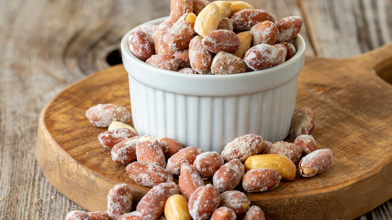 Bowl of peanuts on wooden serving tray