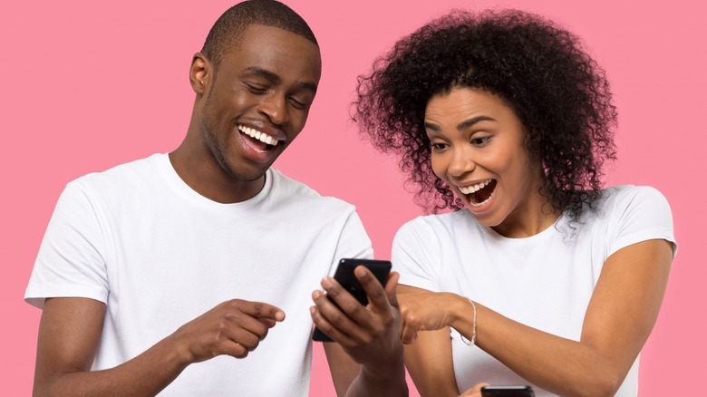 two people laughing at cell phone