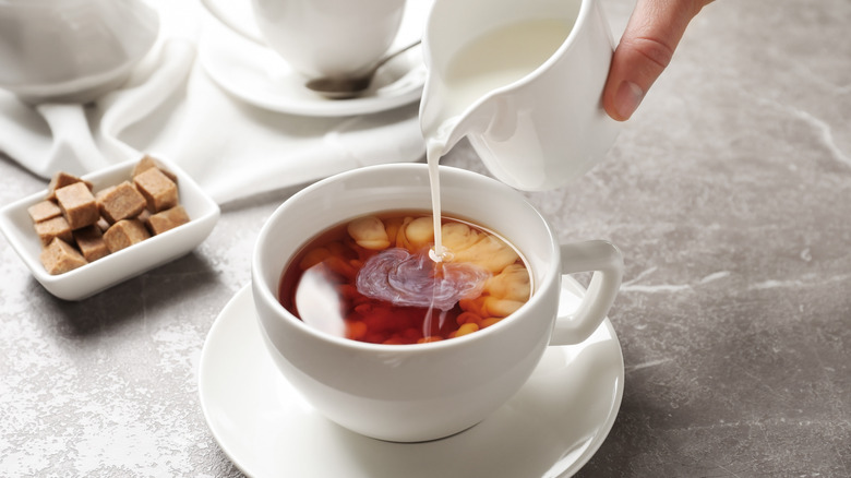 Pouring milk into black tea