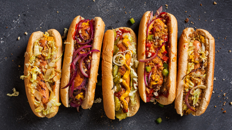 A row of hot dogs on gray slate