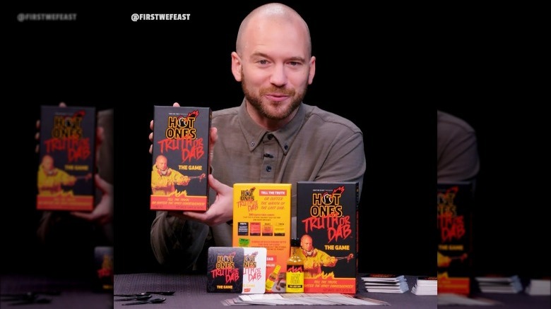 Hot Ones Truth or Dab card game held by Sean Evans