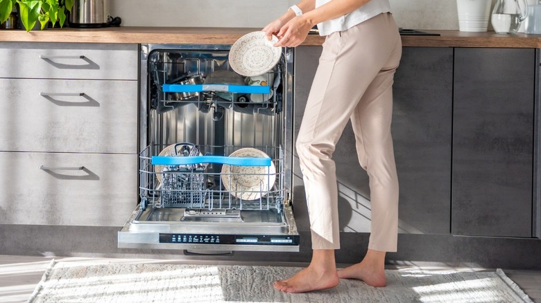 Person loading dishes into dishwasher