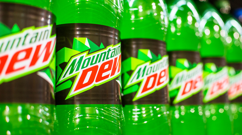 A line of bottles of bright green Mountain Dew soda