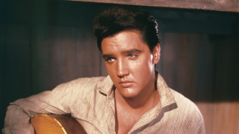 Elvis playing an acoustic guitar