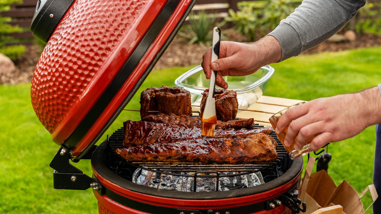 Man putting sauce on ribs