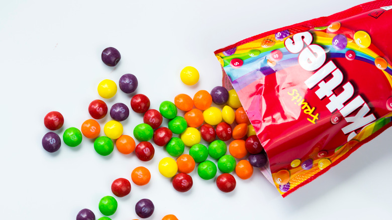 Bag of skittles spilling onto white table