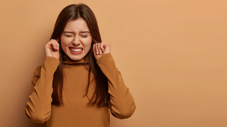 woman plugging her ears