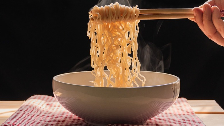 Steaming ramen noodles on chopsticks