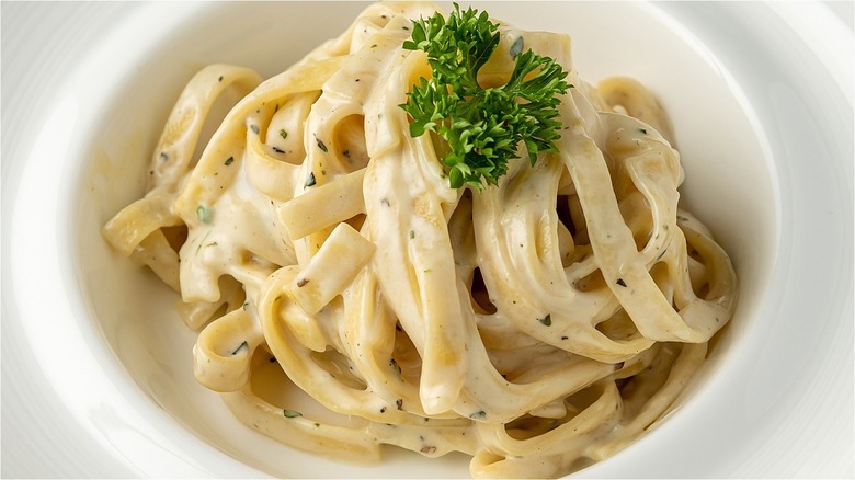 Fettuccine Alfredo dish topped with herbs