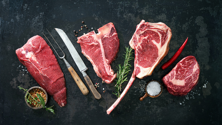 Assortment of raw meat with utensils and spices 