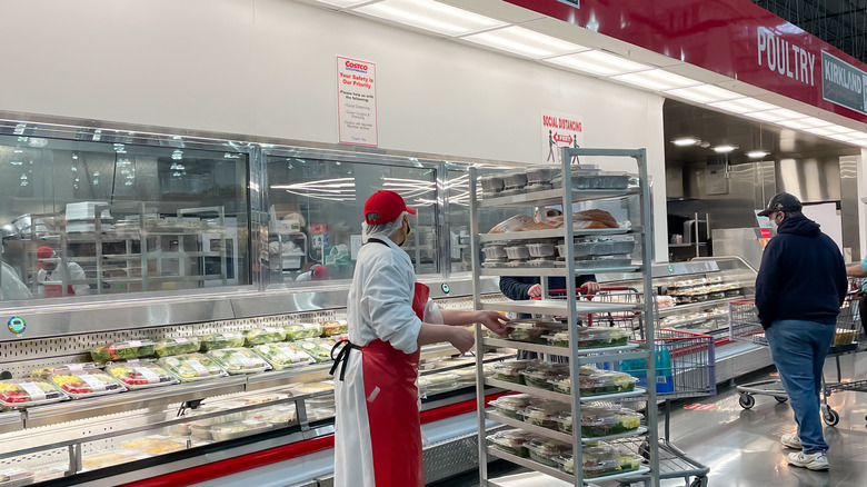 A worker and customer in the Costco deli