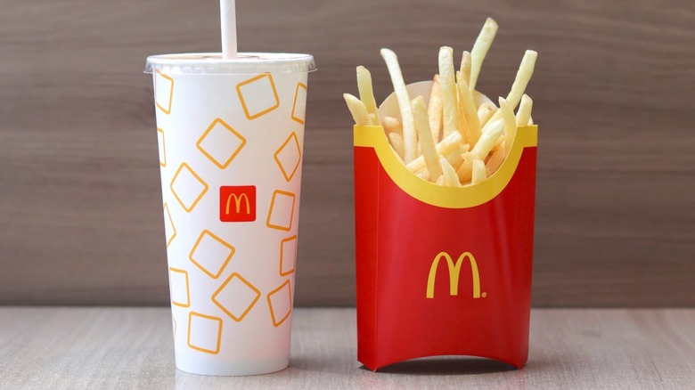 McDonalds fries and a drink against a gray background 