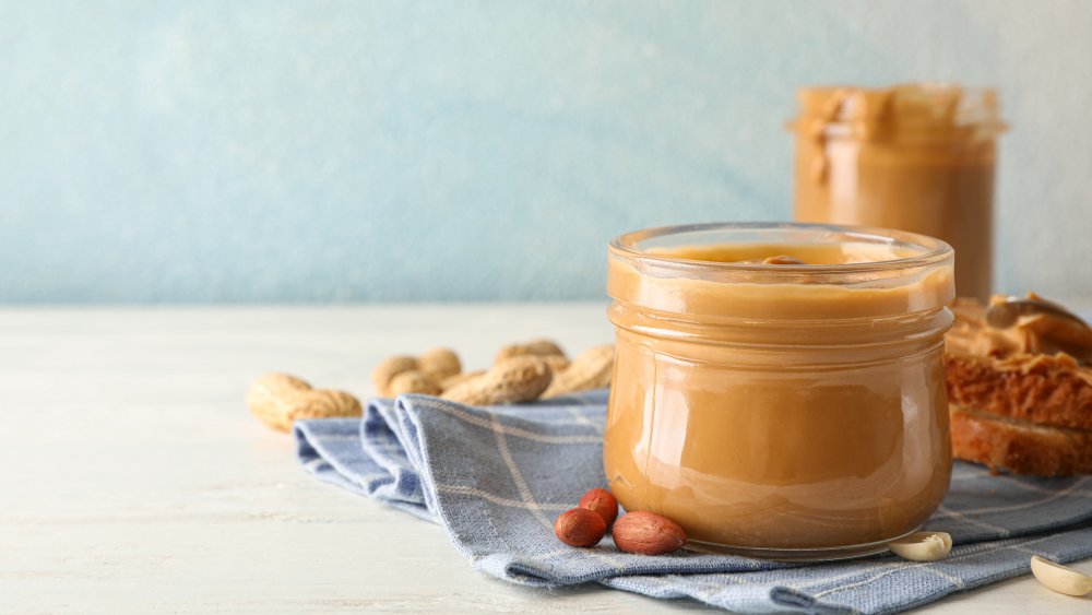 glass jar of peanut butter on a table top