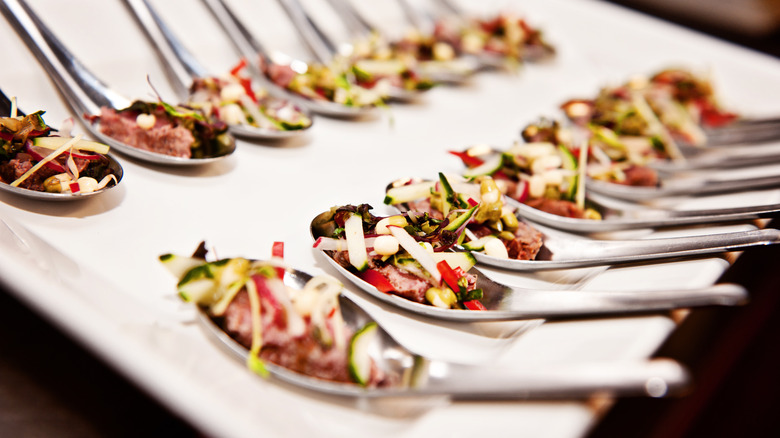 Spoons with appetizer salad on top