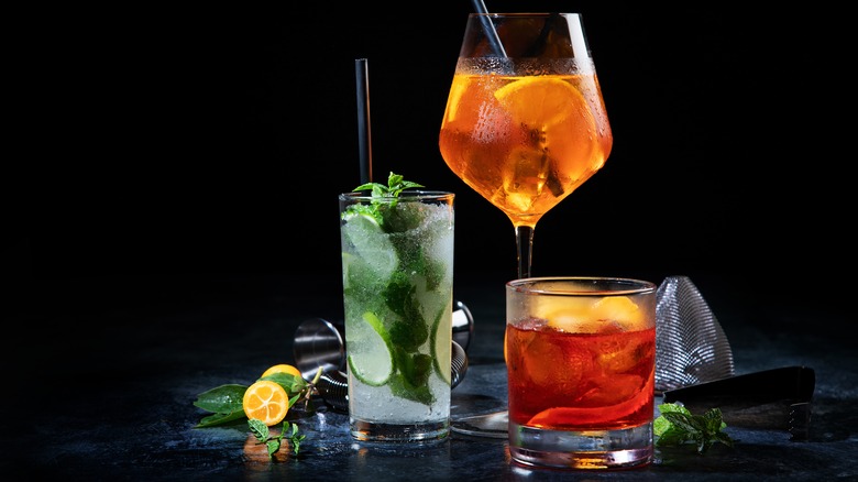 three cocktails and drink making equipment