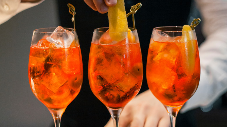 Man garnishing Aperol spritz