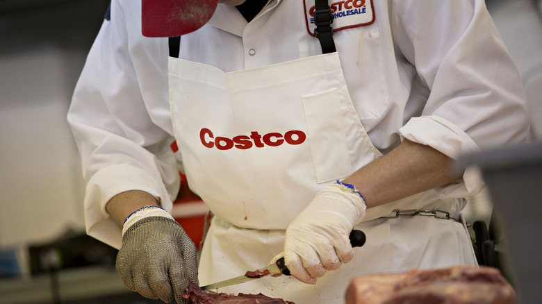 Costco employee preparing meat
