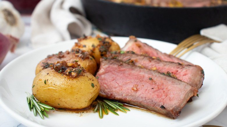 Sliced steak and potatoes on plate