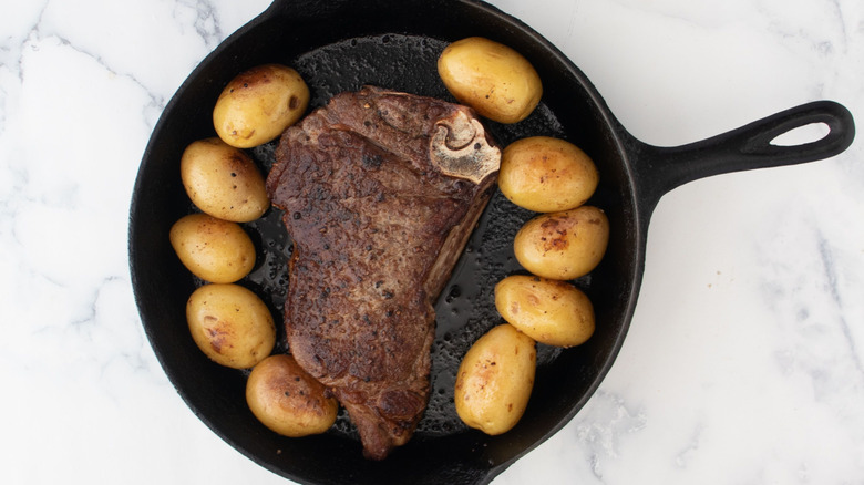 Baby potatoes and steak in skillet