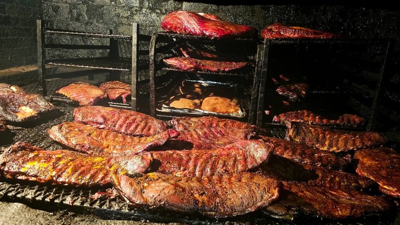 Tons of slabs of brisket sit on racks.