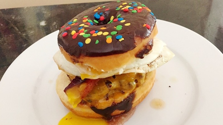 burger on chocolate frosted donut