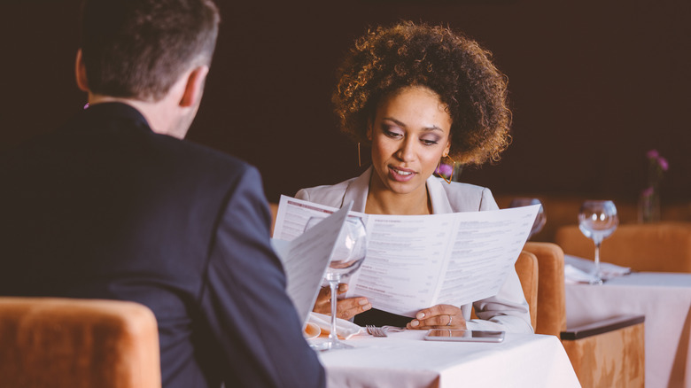coworker and woman reading restaurant menu