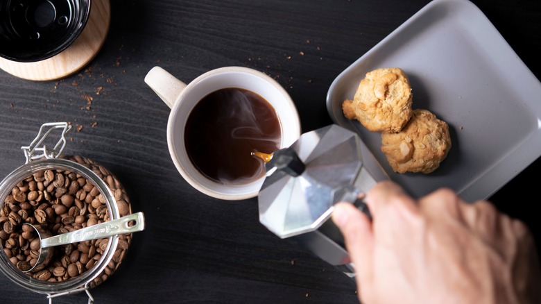 person pouring black coffee