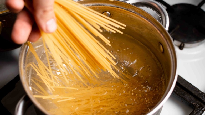Adding dry pasta to water