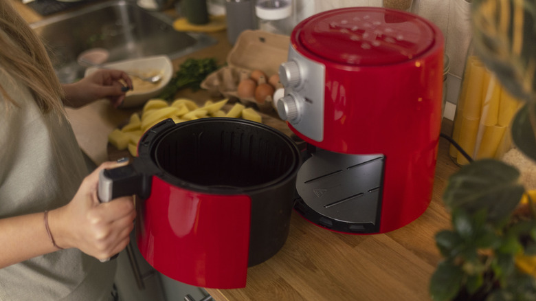 person using an air fryer at home