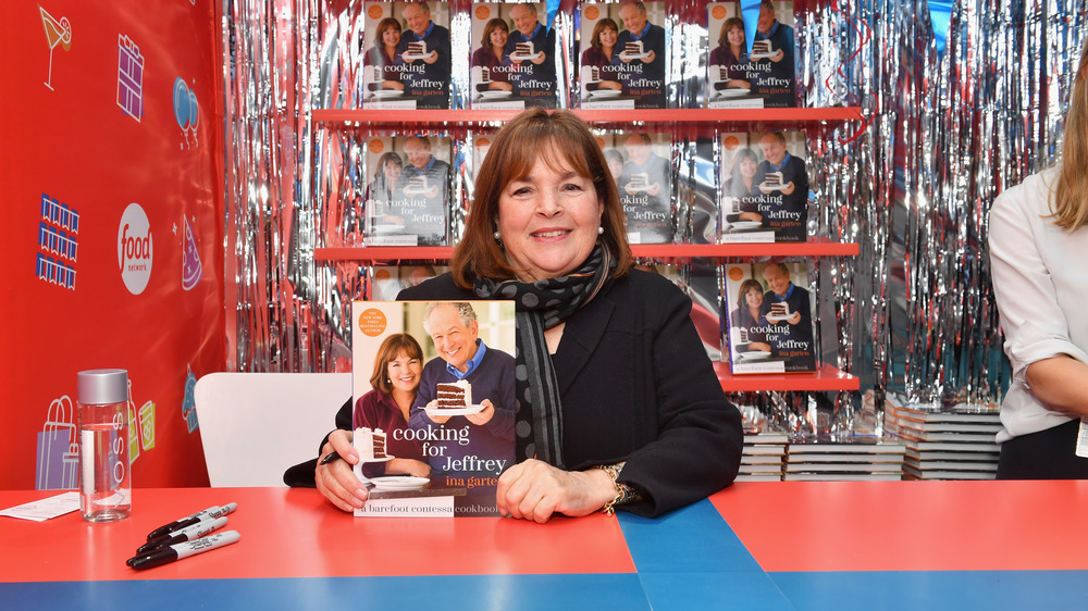 Ina Garten holding up a cook book