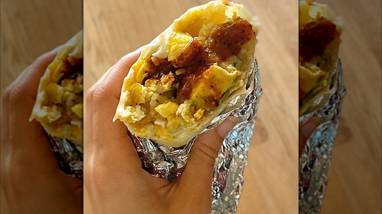 Breakfast burrito with sauce in foil