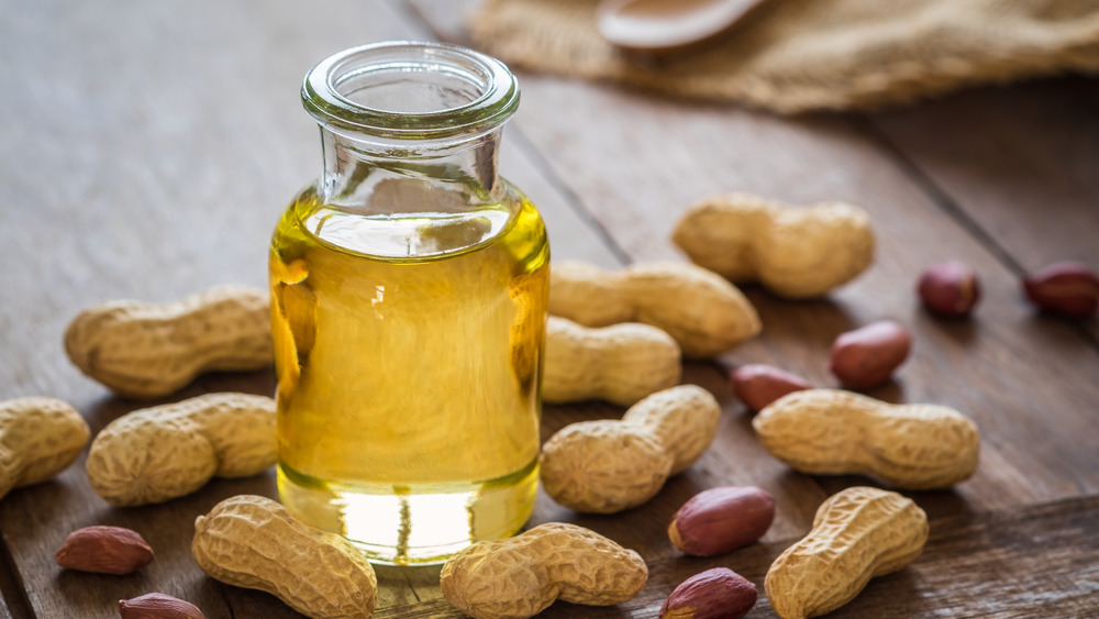 Peanut oil bottle and peanuts