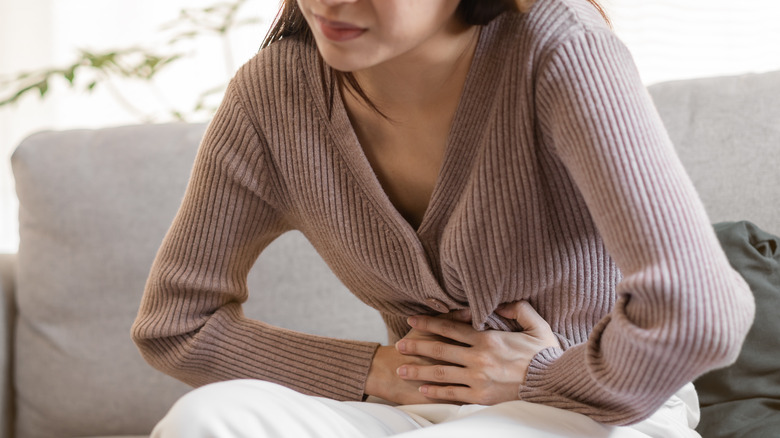 woman holding her stomach 