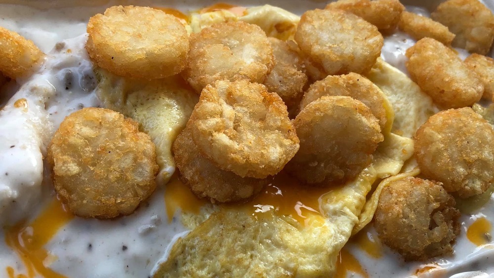Scrambled eggs, sauce, and cheese topped by hash browns