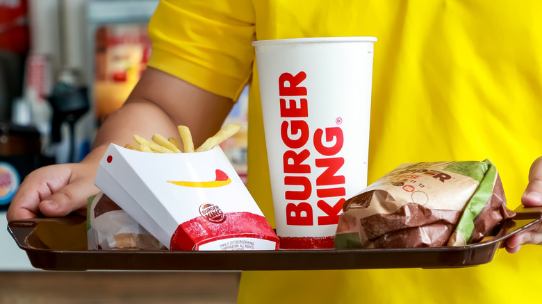 Person holding a tray of Burger King food
