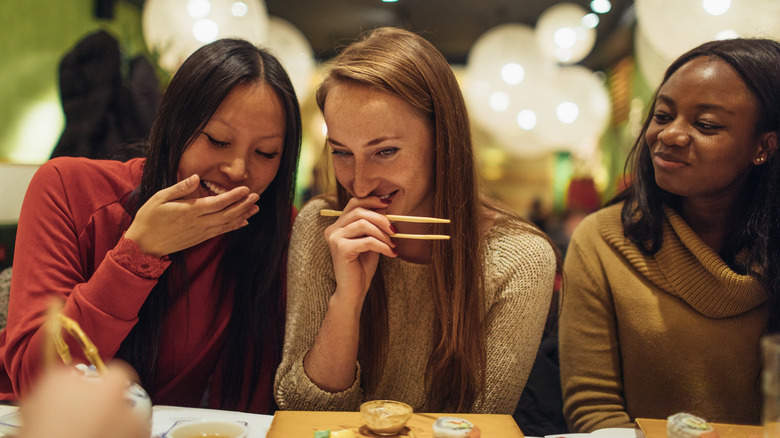 Girls smiling and giggling while enjoying dinner