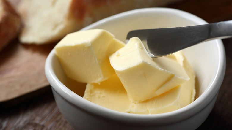 Knife cutting through soft butter