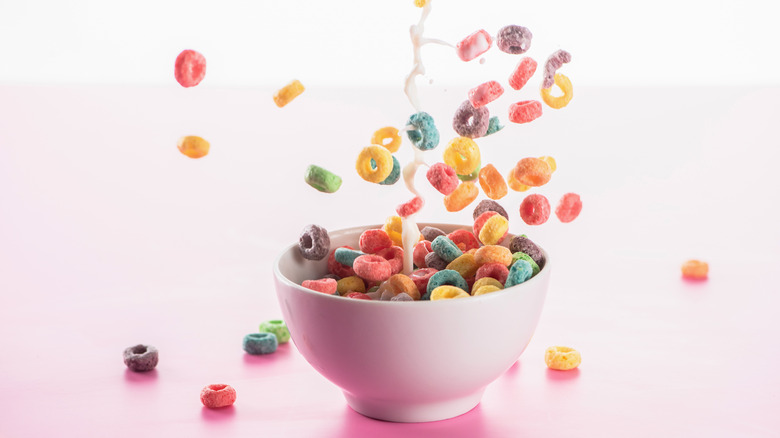 Colorful cereal dropping into a bowl with pouring milk