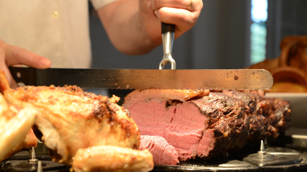 man carving red meat