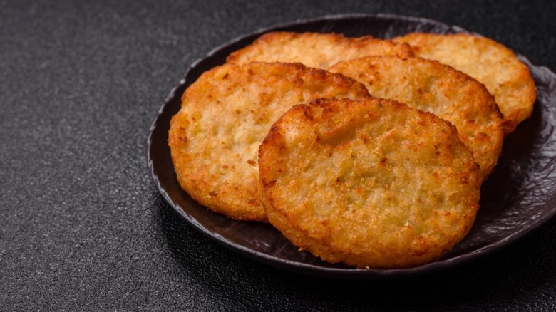 Hash brown patties on a black plate