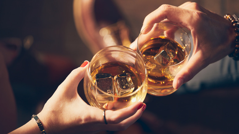 People cheers with whiskey