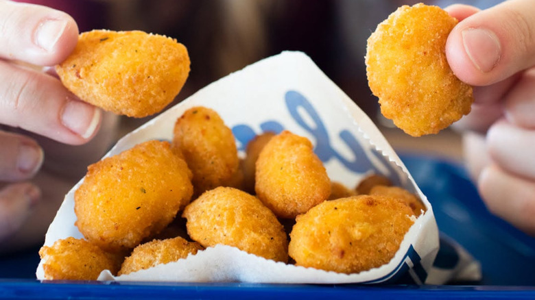 Culver's cheese curds in white paper bag.